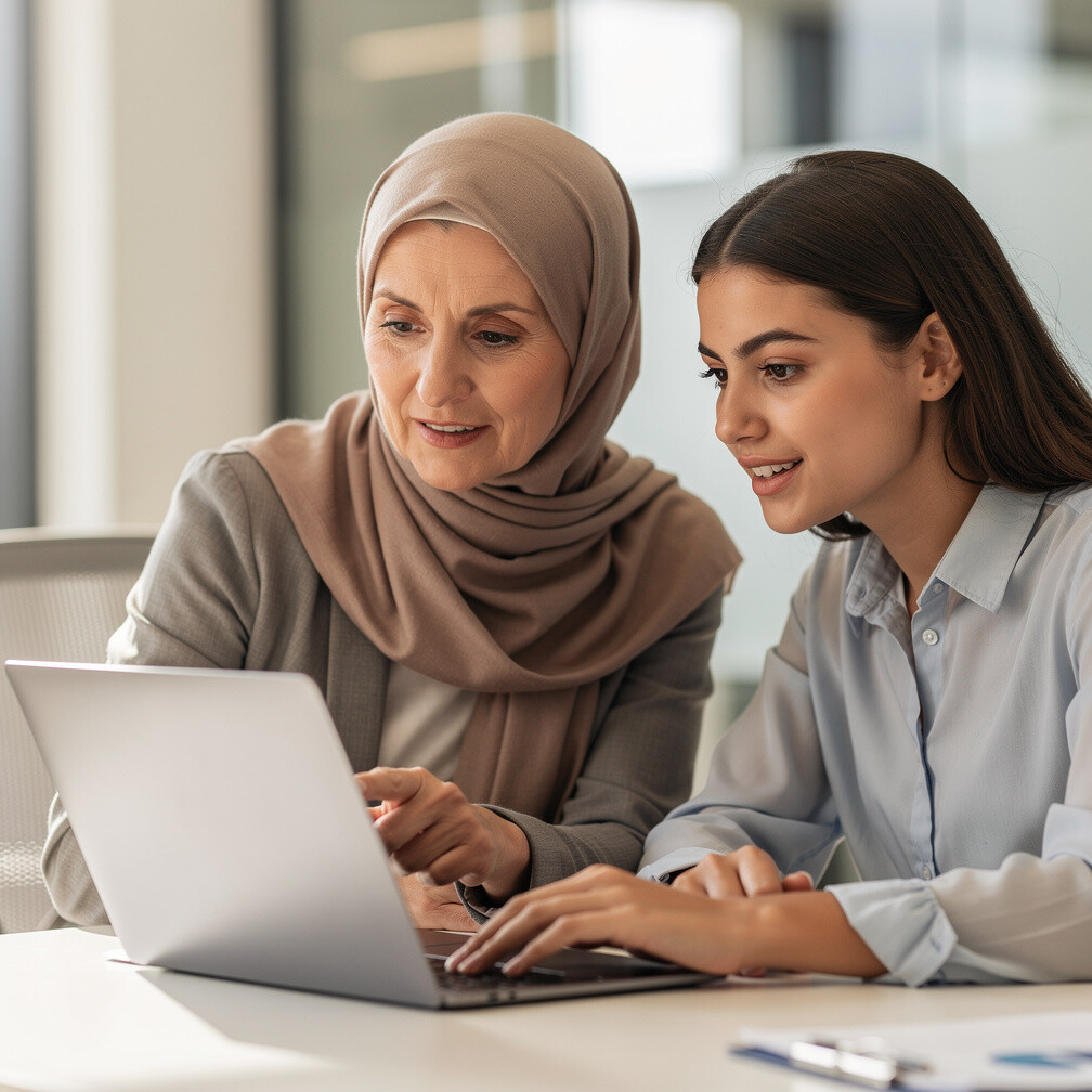 Woman mentoring a colleague at a laptop